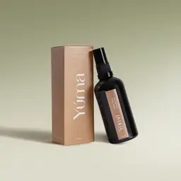 YUMA Pine Tree Fabric Mist in a dark glass bottle next to its beige paper packaging.