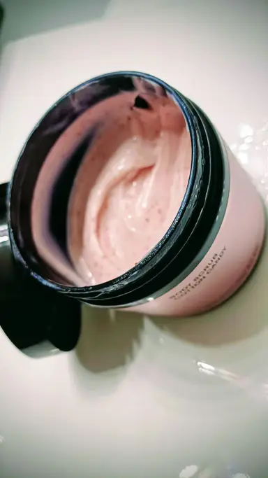 An open jar of pink creamy Cotton Candy Body Scrub containing small exfoliating granules.