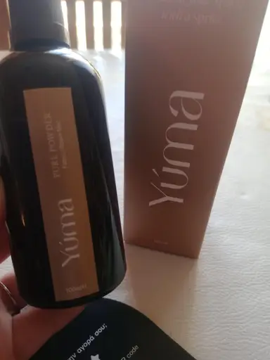 YUMA Pure Powder dark glass bottle next to its paper packaging on a beige background.