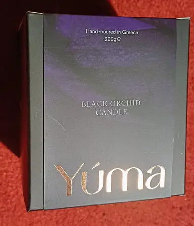 Black box for the YUMA Black Orchid CANDLE with a gold logo and purple accents.