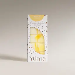 YUMA Oriental Mimosa wax melts in a white box with brown speckles and a yellow wax piece.