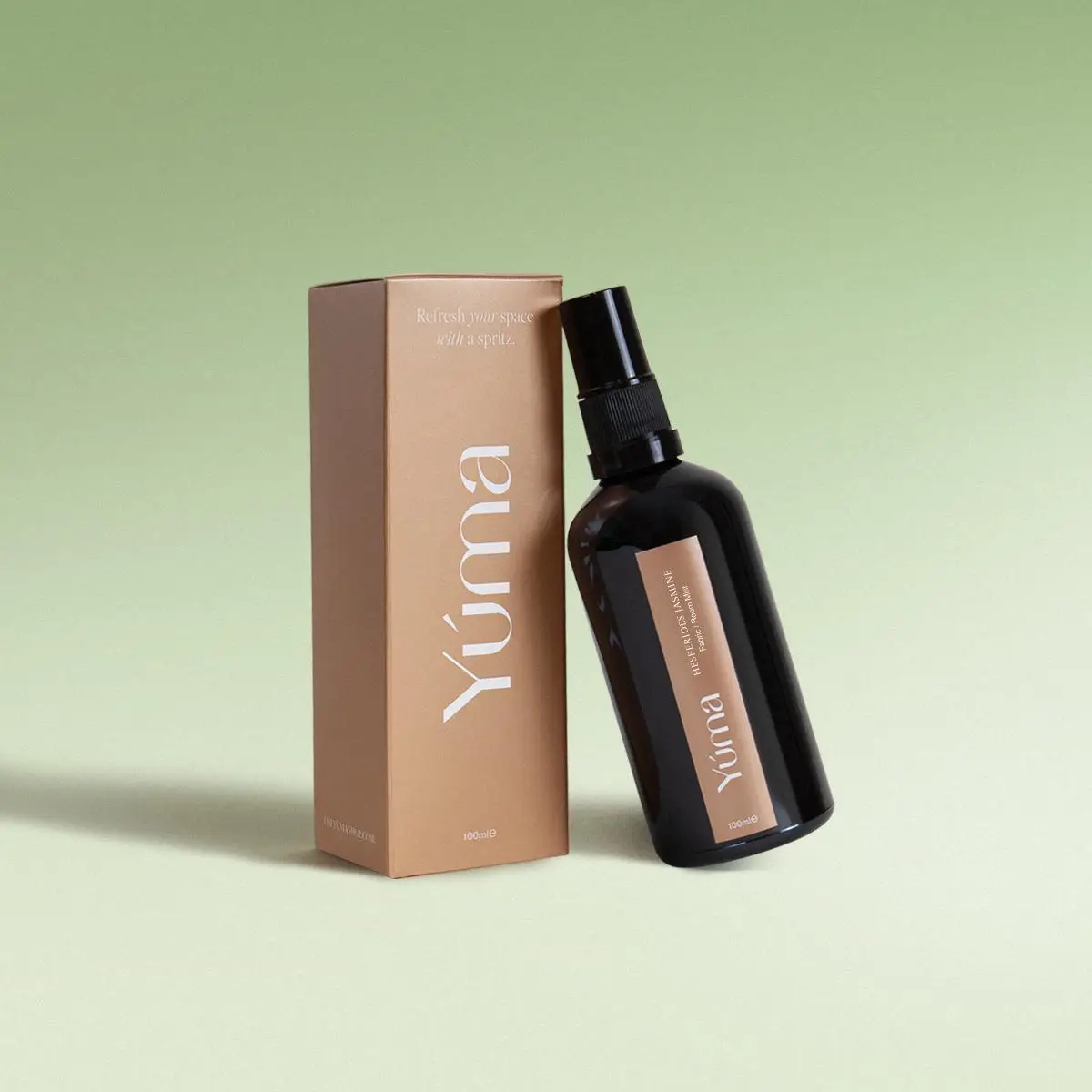YUMA Fabric Mist Hesperides Jasmine dark glass bottle next to its beige paper packaging.