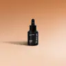 YUMA Car Diffuser Refill black bottle in Orange Spices scent on a beige background.