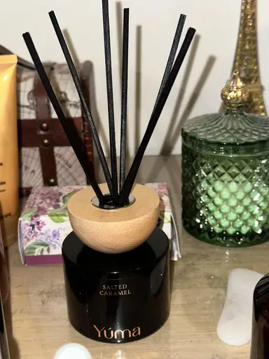 YUMA Salted Caramel black room diffuser with a wooden lid and black reeds.