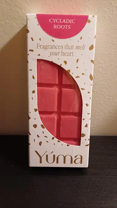 A pink chocolate-shaped wax melt inside white YUMA packaging with gold detailing.