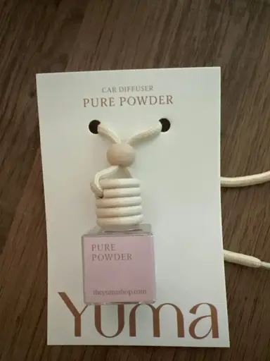 Small YUMA Pure Powder glass car diffuser with a wooden cap and white cord.