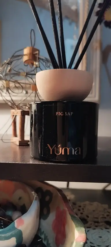 YUMA Fig Sap black glass reed diffuser with a wooden lid and black diffuser sticks.