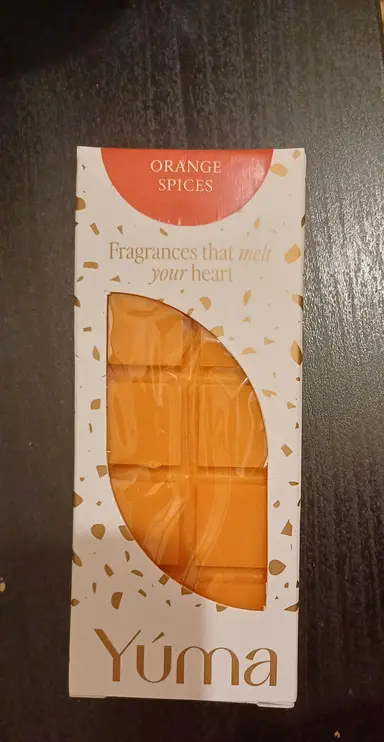 An orange YUMA wax melt in white packaging with gold details and the Orange Spices label.