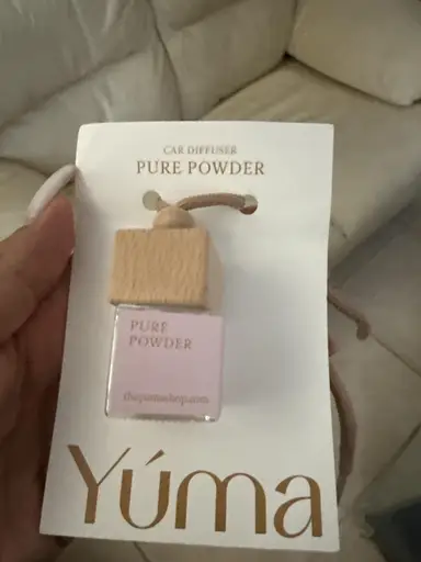 YUMA Pure Powder car fragrance in a small glass bottle with a wooden cap and cord.