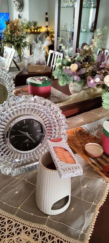 A crystal clock beside a white wax melt burner and a YUMA Orange Spices package.