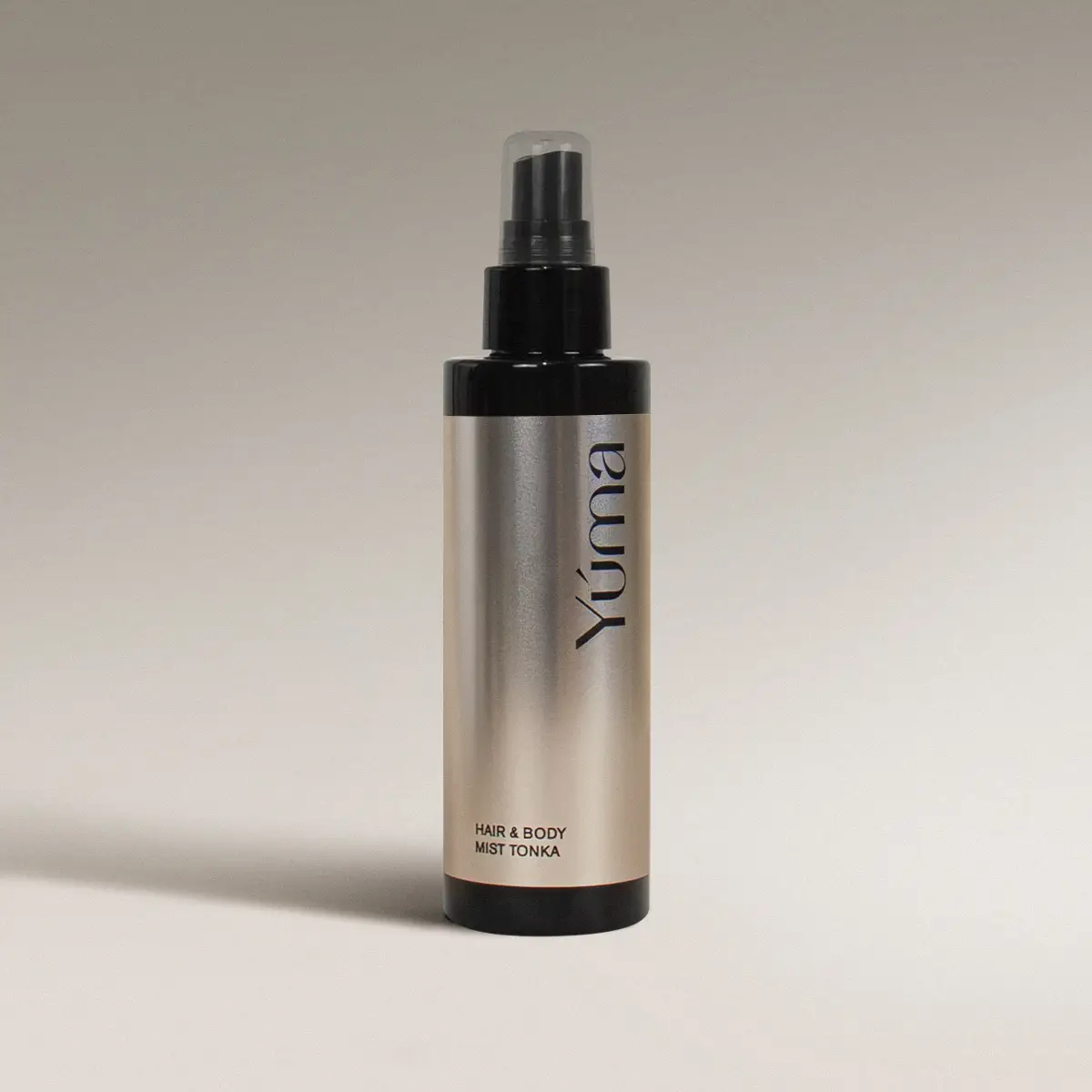 YUMA Tonka Hair & Body Mist in a metallic bottle with a black spray cap.