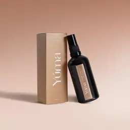 YUMA Amber Tobacco Fabric Mist black bottle beside its beige box on a plain background.