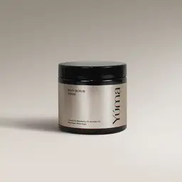 YUMA Tonka scented Body Scrub in a black jar with a silver label on a grey background.