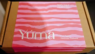 YUMA paper packaging box with a pink and red striped label for Pure Powder.