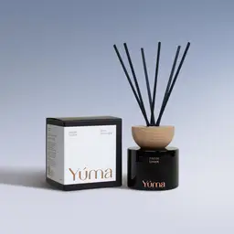 YUMA Fresh Linen reed diffuser in a black glass bottle next to its paper packaging.