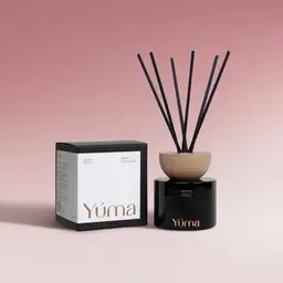 YUMA Peony Velvet black reed diffuser with a wooden lid and black reeds, next to its packaging.
