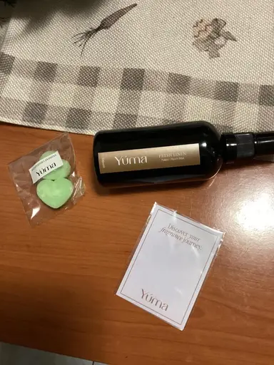 A YUMA Fresh Linen room mist next to green heart-shaped wax melts.