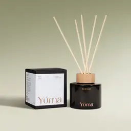 YUMA Pine Tree reed diffuser in a dark glass bottle next to its paper packaging.