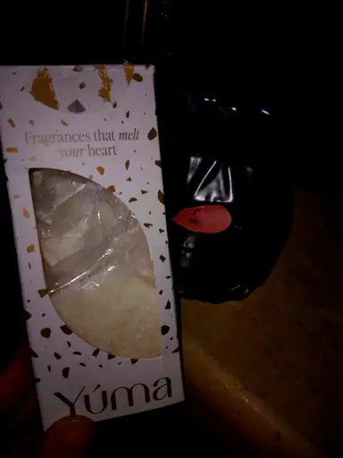 YUMA wax melts packaging next to a black ceramic burner with a lit tealight.