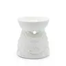 White ceramic oil burner with raised decorative patterns and brown speckles on a white background.