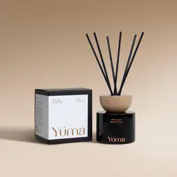 YUMA Antique Bookcase reed diffuser in a black glass bottle with a wooden cap, next to its paper packaging.