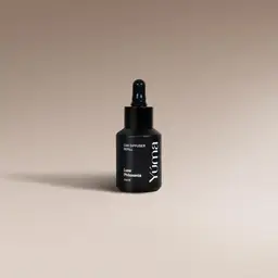 YUMA Car Diffuser Refill black bottle with dropper on a beige background.