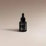 YUMA Car Diffuser Refill black bottle with dropper on a beige background.