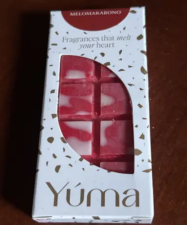 A white YUMA wax melt package in the MELOMAKARONO scent, containing a red and white embossed wax bar.