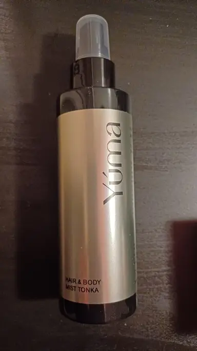 A YUMA Tonka Hair & Body Mist in a metallic cylindrical bottle with a transparent cap.