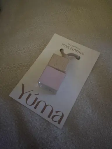 Small YUMA Pure Powder glass car fragrance with a wooden cap, placed on a white card.