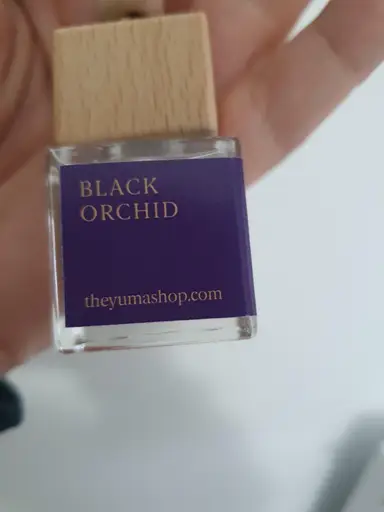 Small glass bottle with a wooden cap and a purple label reading Black Orchid.