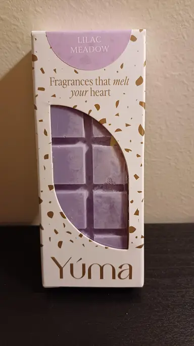 Purple chocolate-shaped wax melt inside white YUMA packaging with gold details.