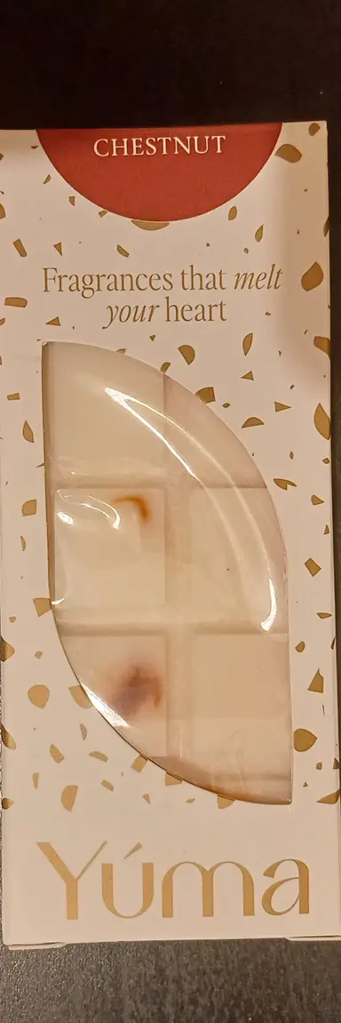 A white YUMA wax melts bar in paper packaging with gold details, Chestnut scent.