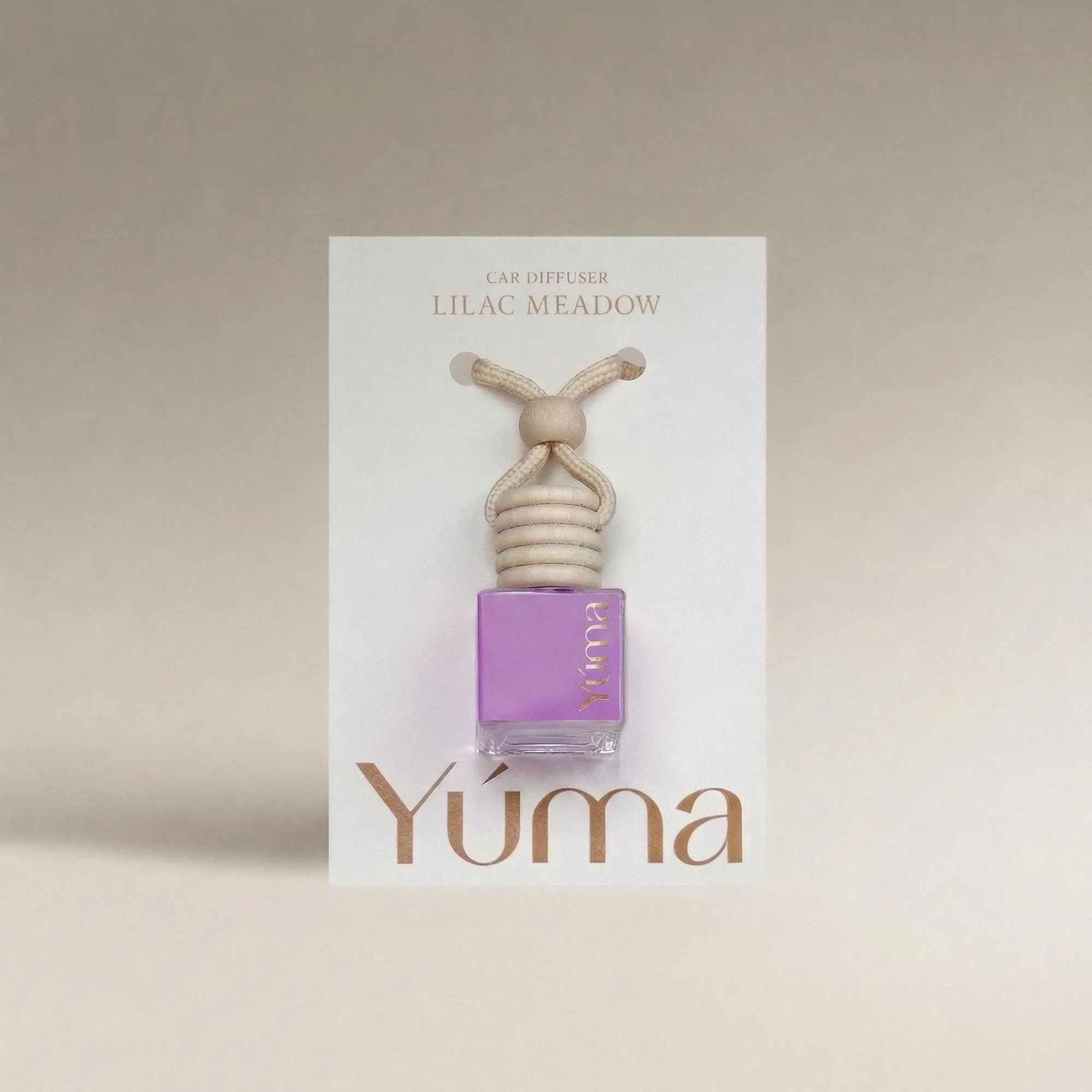 YUMA Lilac Meadow Car Diffuser in a purple glass bottle with a wooden cap and cord.