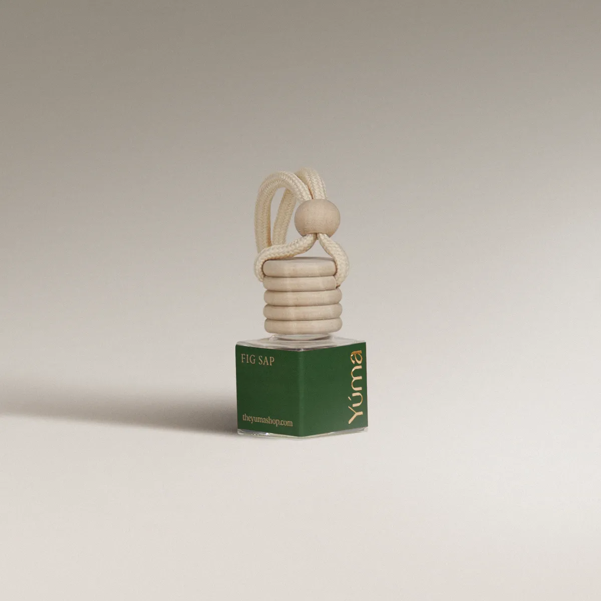 YUMA Fig Sap glass car diffuser with a green label, wooden cap, and hanging rope cord.