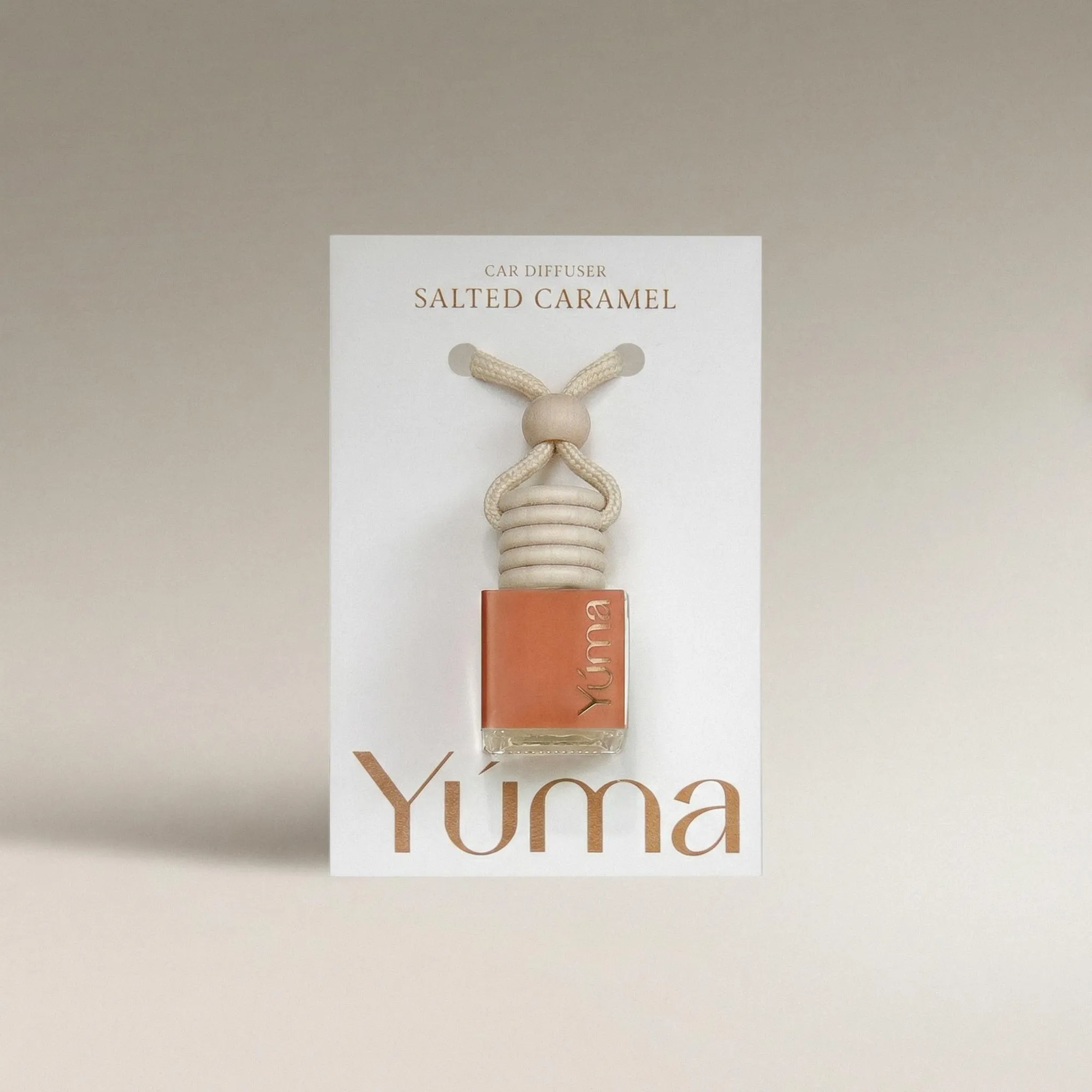 YUMA Salted Caramel Car Diffuser in a glass bottle with a wooden cap and rope.