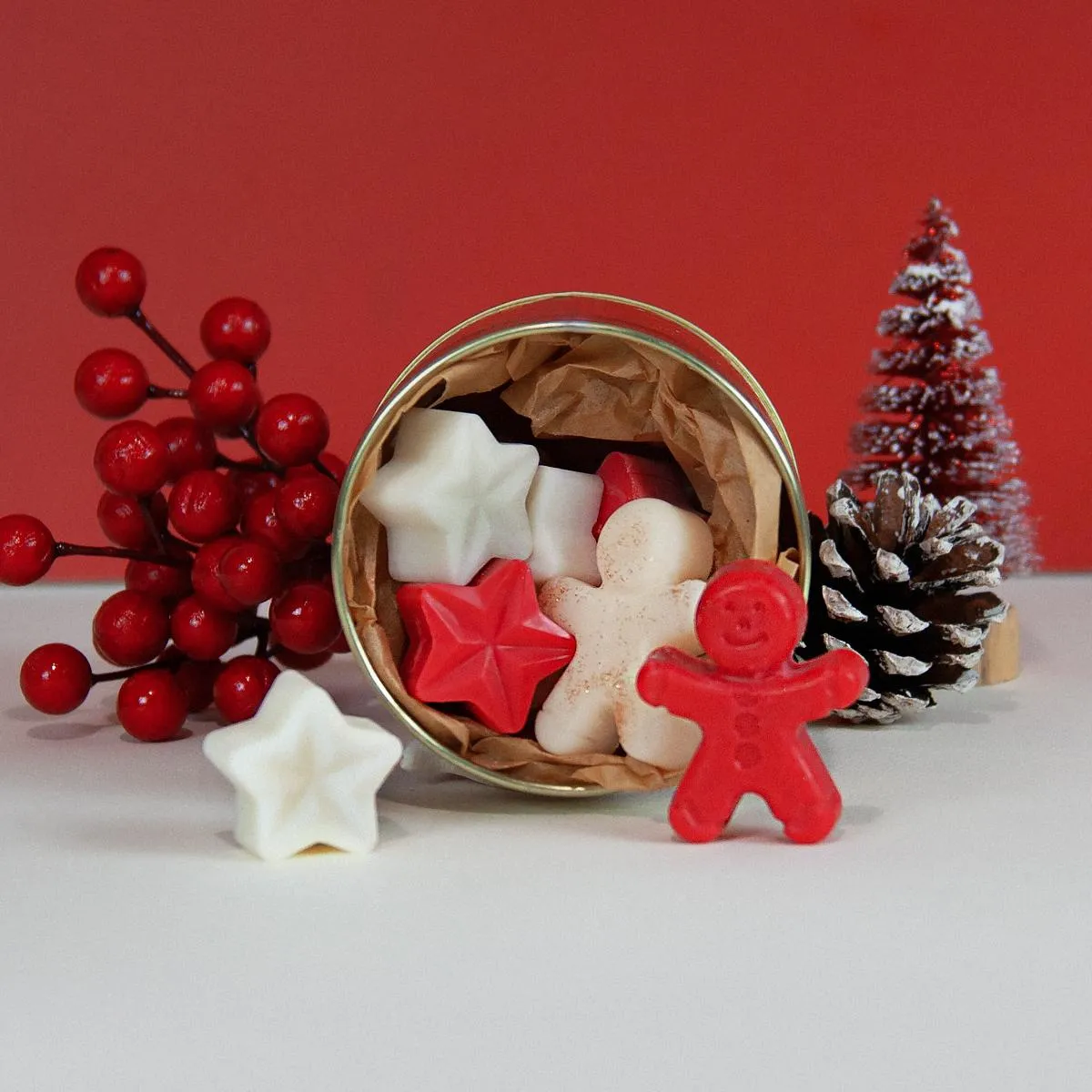 Red and white star- and gingerbread-man-shaped Melomakarono wax melts in a metal tin.