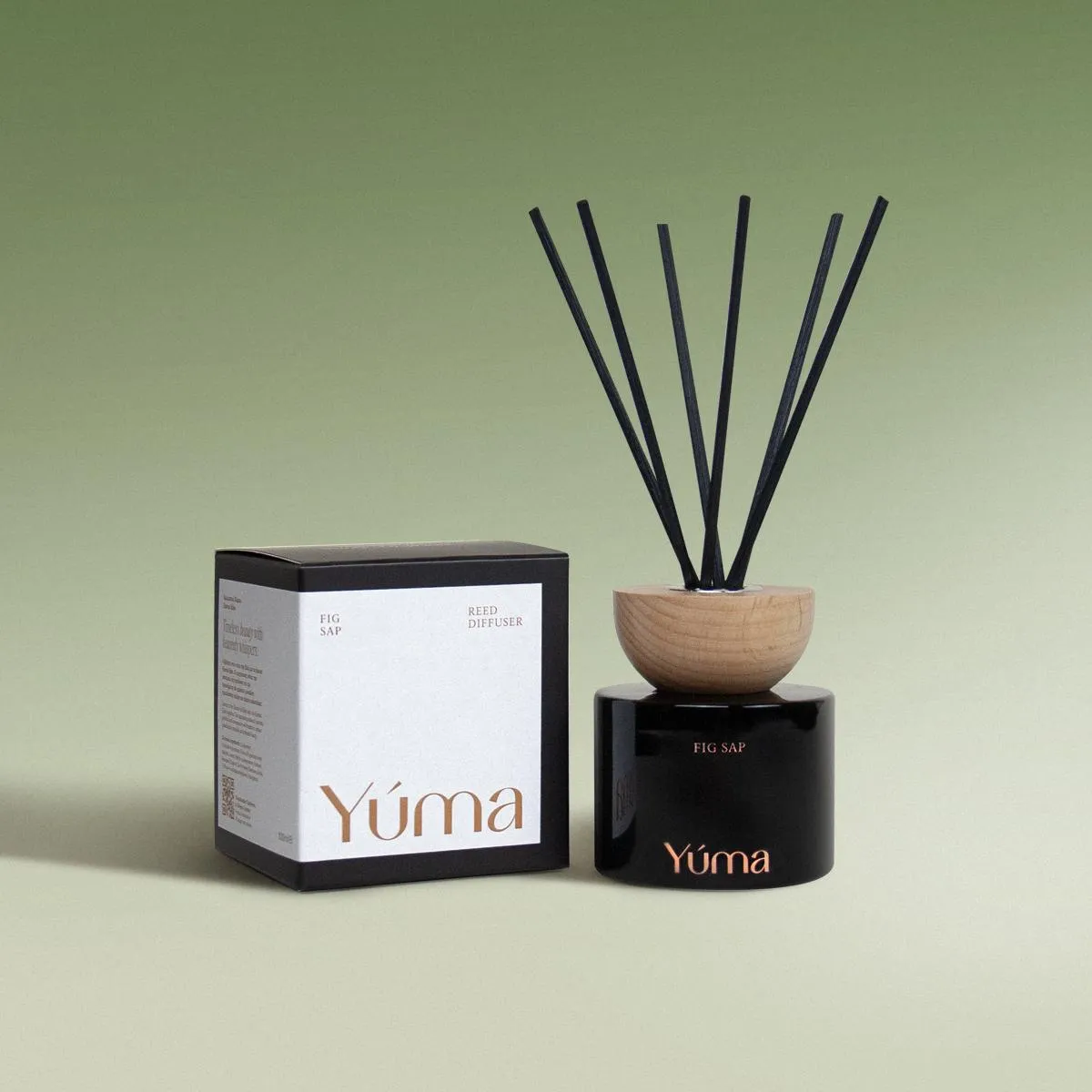 YUMA Fig Sap black glass reed diffuser with a wooden lid next to its packaging.