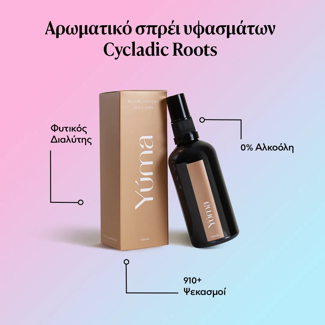 YUMA Cycladic Roots fabric spray in a dark glass bottle next to its gold packaging.