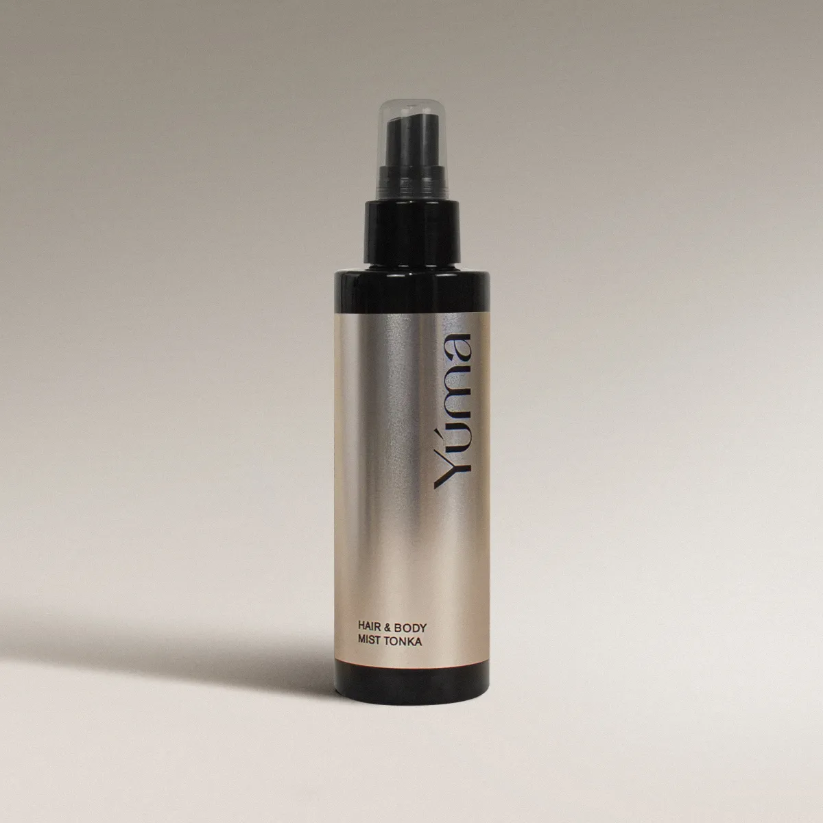 YUMA Tonka Hair & Body Mist in a metallic bottle with a black spray cap.