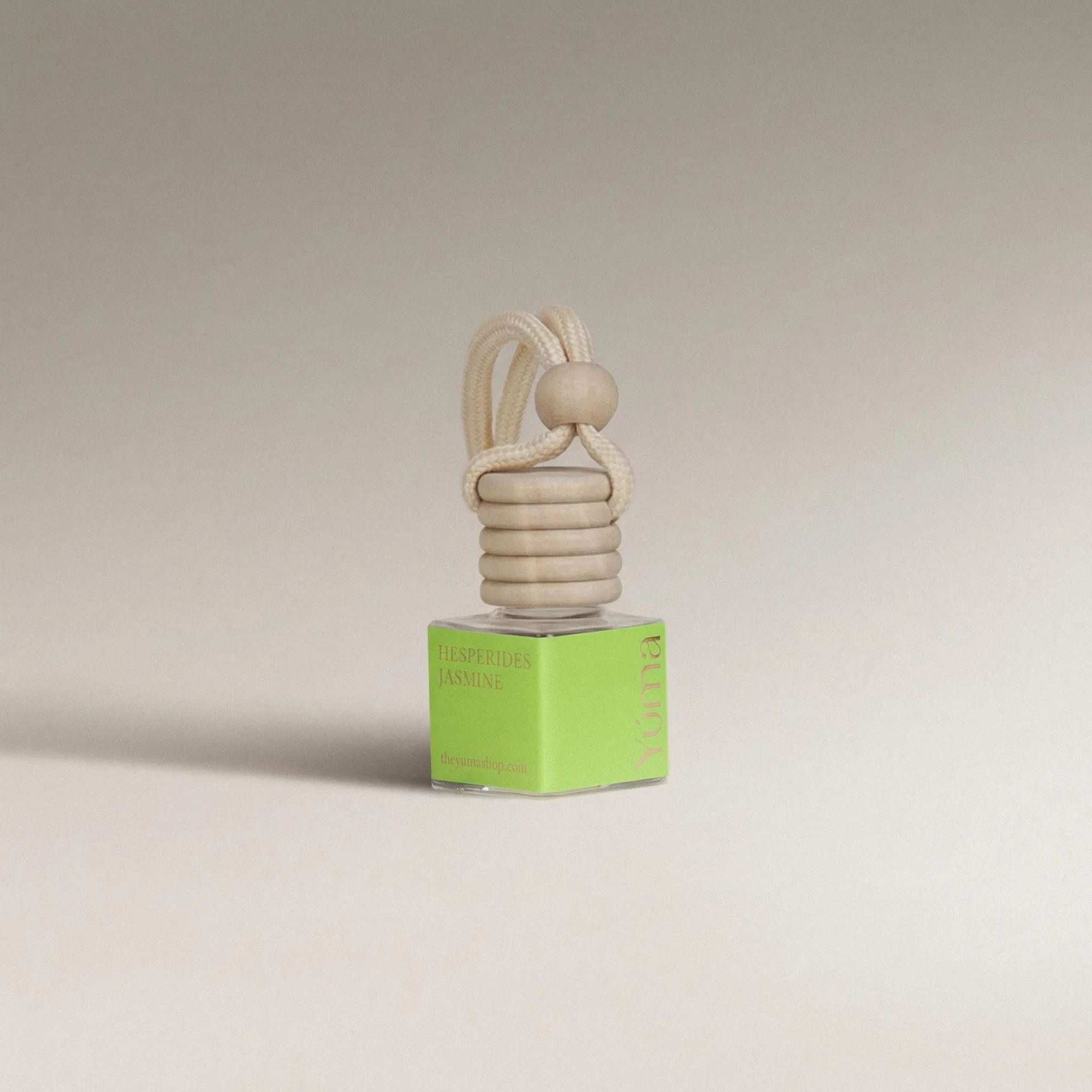 YUMA Hesperides Jasmine Car Diffuser in a small glass bottle with a green label and wooden cap.