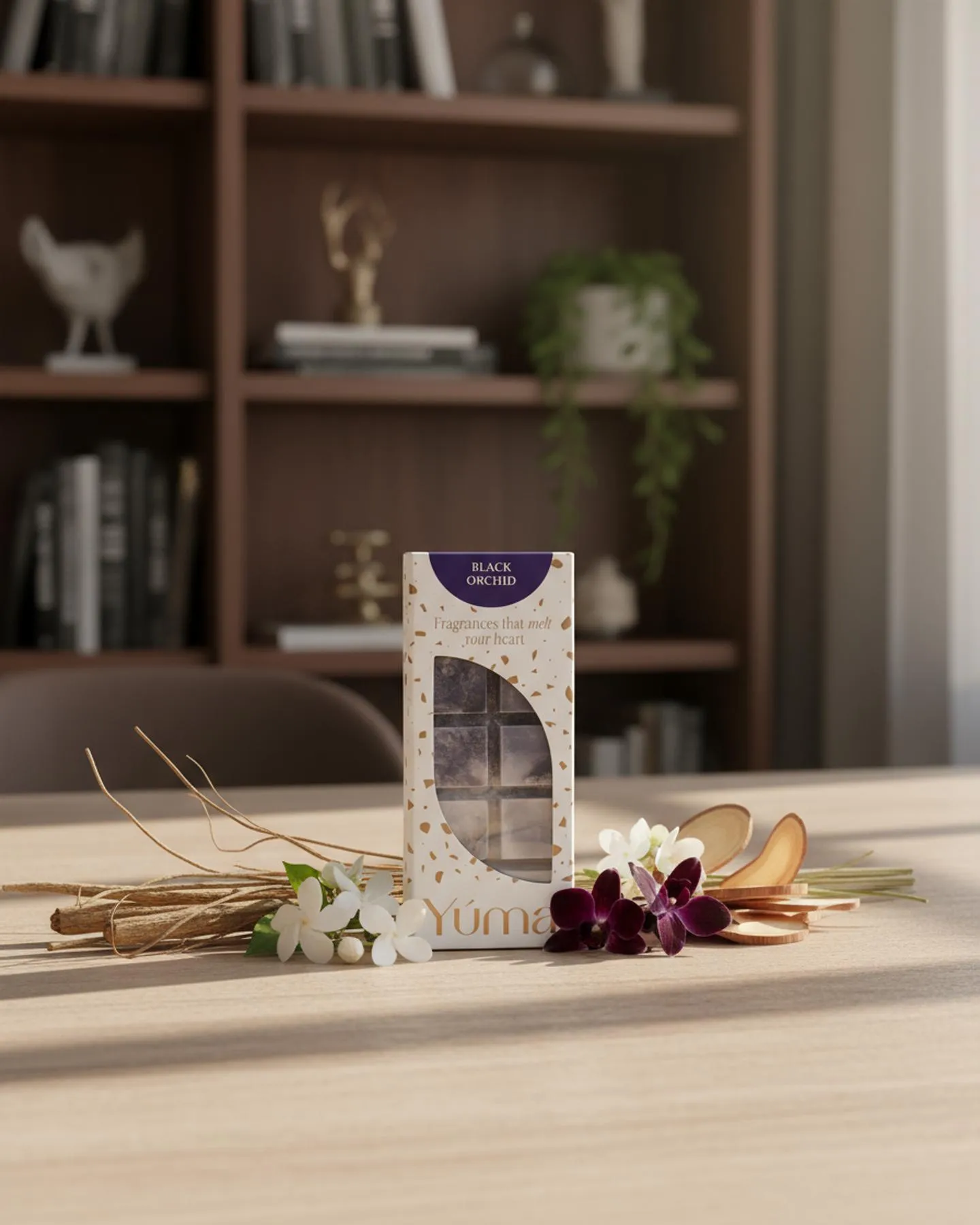 YUMA Black Orchid Wax Melts packaging on a wooden table with white and purple flowers.