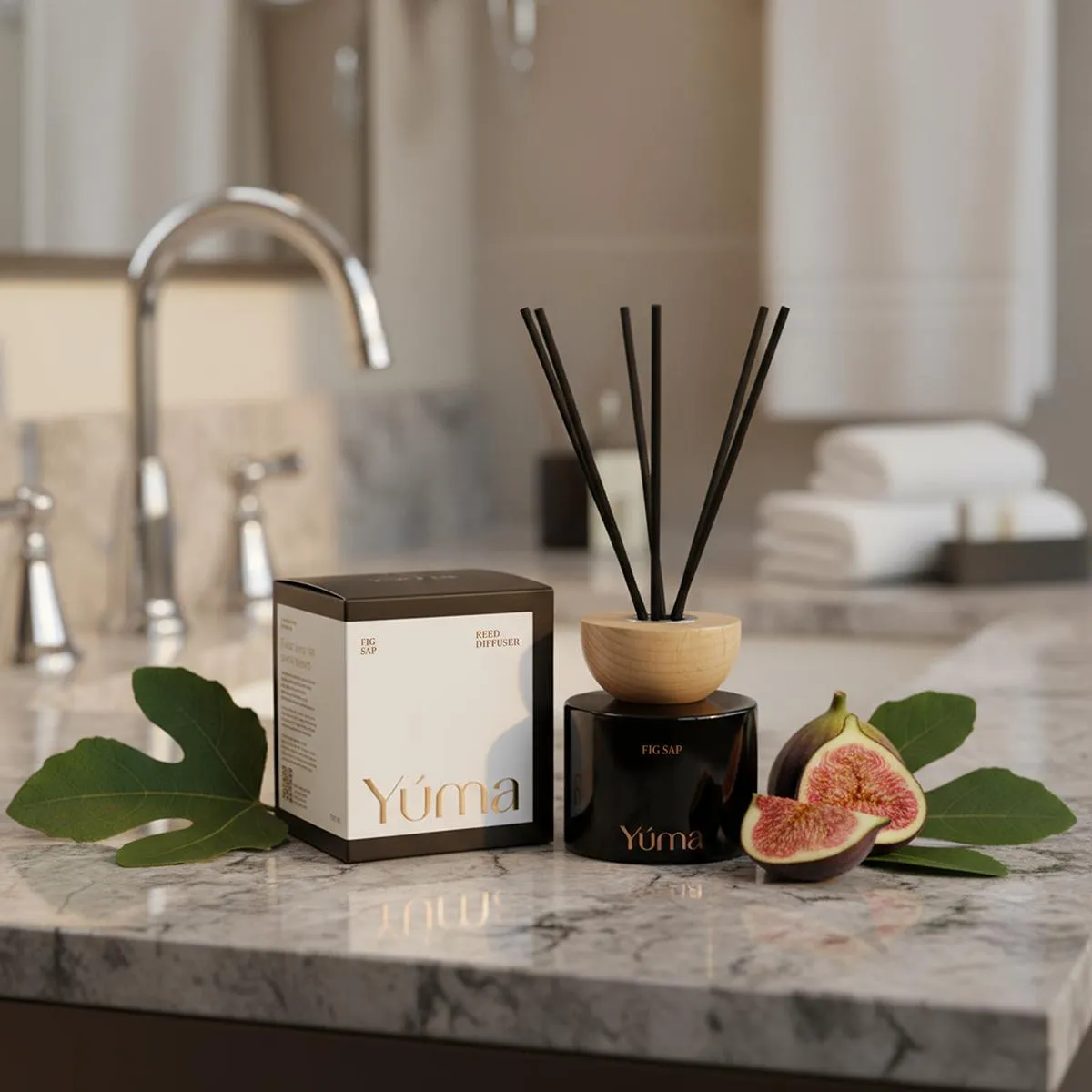 YUMA Fig Sap reed diffuser in a black jar, placed beside fresh figs on a marble surface.