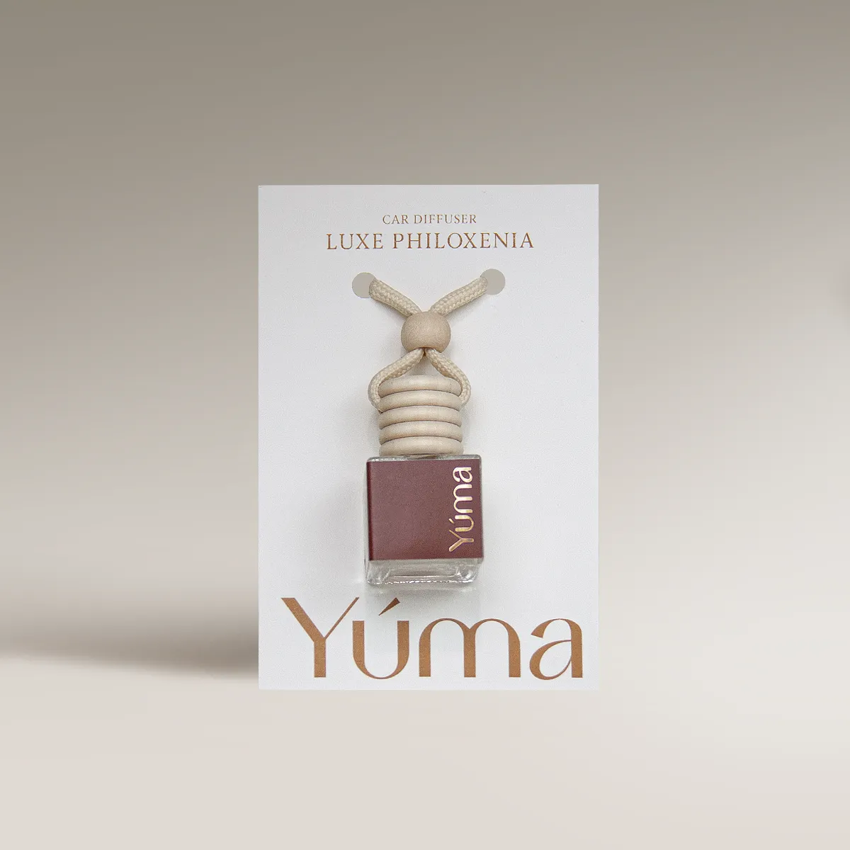 YUMA Luxe Philoxenia Car Diffuser in a glass bottle with a wooden cap and cord.