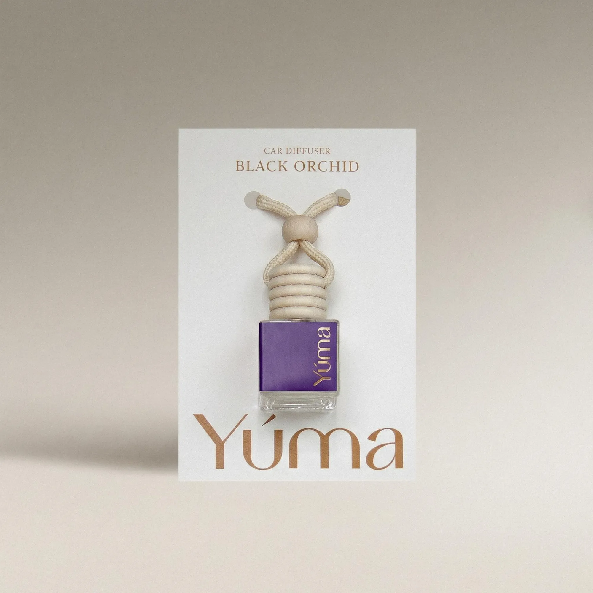 YUMA Black Orchid Car Diffuser in a purple glass bottle with a wooden cap.