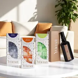 Anti Tobacco Set Three YUMA wax melts and an Eternal Eden room spray on a white table in front of a sofa.
