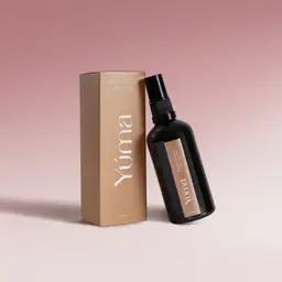 Peony Velvet Fabric Mist A black YUMA Peony Velvet Fabric Mist bottle next to its beige paper packaging.