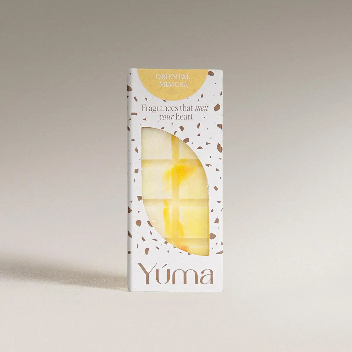 Oriental Mimosa Snap Bar YUMA Oriental Mimosa wax melts in a white box with brown speckles and a yellow wax piece.