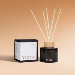 Pumpkin Pie Reed Diffuser YUMA Pumpkin Pie reed diffuser in a dark glass bottle beside its paper packaging.