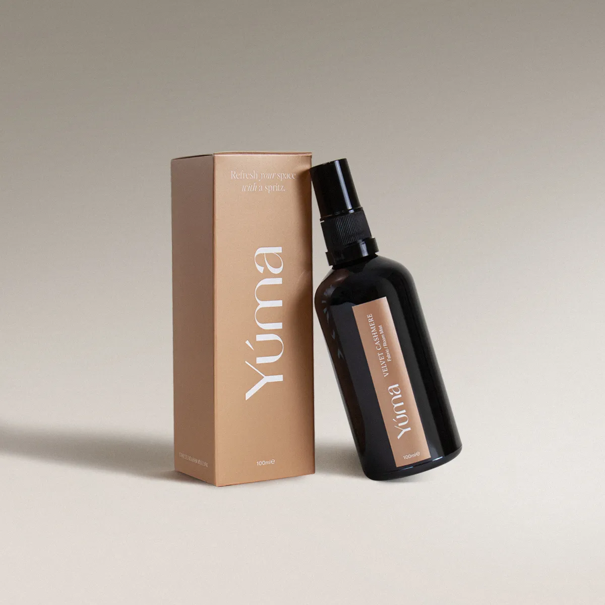 Fabric Mist - Velvet Cashmere - Scented Fabric Spray YUMA Velvet Cashmere Fabric Mist in a dark glass bottle next to its paper packaging.